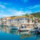 Το γραφικό λιμάνι του Λιμένα Θάσου με αλιευτικά σκάφη και παραδοσιακή αρχιτεκτονική.