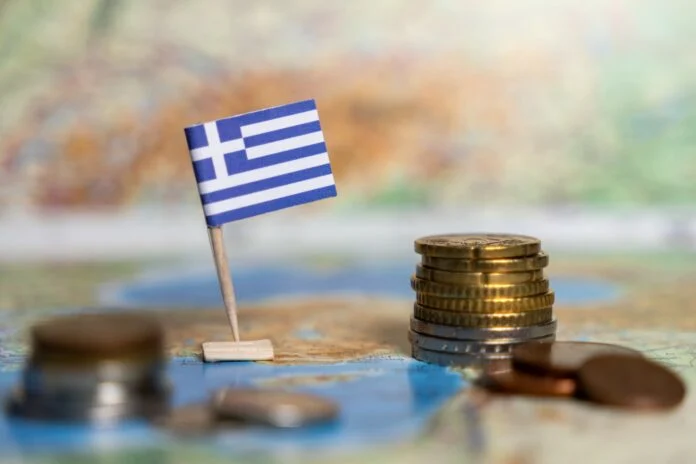 Άποψη της Αθήνας με οικονομικά γραφήματα που απεικονίζουν τη μείωση του δημόσιου χρέους και την πορεία της οικονομίας
